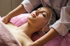 Calm girl having spa facial massage in luxurious beauty salon stock photo Calm girl having spa facial massage in luxurious beauty salon stock photo