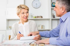 Calm mature couple at table attentively study documents stock image Calm mature couple at table attentively study documents stock image