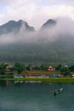 Calm river with boats in the National Park of Phong Nha Ke Bang, Vietnam. Beautiful sunrise with hanging clouds in the hills. stock photo Calm river with boats in the National Park of Phong Nha Ke Bang, Vietnam. Beautiful sunrise with hanging clouds in the hills. stock photo