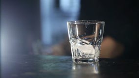 Camarero que vierte un whisky escocés con hielo en la barra Tirado con el resbalador metrajes Camarero que vierte un whisky escocés con hielo en la barra Tirado con el resbalador metrajes