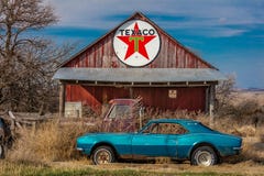 Camaro azul abandonado Chevrolete delante de la estación abandonada de Texaco, parte remota de Nebraska fotos de archivo libres de regalías Camaro azul abandonado Chevrolete delante de la estación abandonada de Texaco, parte remota de Nebraska fotos de archivo libres de regalías
