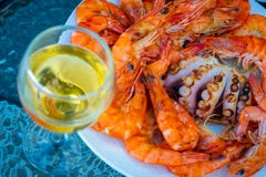 Camarones asados a la parrilla frescos, pulpo en el plato y vidrio de vino blanco fotografía de archivo Camarones asados a la parrilla frescos, pulpo en el plato y vidrio de vino blanco fotografía de archivo