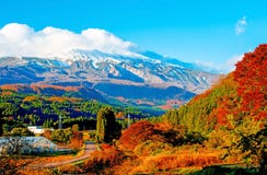 Cambiamento di colore delle foglie, foglie di autunno e alte montagne coperte di neve e di nuvole bianche in Akita, il Giappone fotografia stock libera da diritti Cambiamento di colore delle foglie, foglie di autunno e alte montagne coperte di neve e di nuvole bianche in Akita, il Giappone fotografia stock libera da diritti