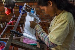 Cambodjaanse vrouwen wevende zijde bij een zijdelandbouwbedrijf stock afbeelding Cambodjaanse vrouwen wevende zijde bij een zijdelandbouwbedrijf stock afbeelding
