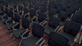 Camera moves among a lot of comfortable seats in empty audience hall. Preparing for the marketing conference in the big stock footage Camera moves among a lot of comfortable seats in empty audience hall. Preparing for the marketing conference in the big stock footage