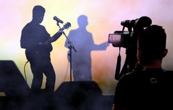 Cameraman recording and broadcasting live on concerts using video camera