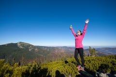 Caminante femenino feliz joven en el top de la montaña imágenes de archivo libres de regalías Caminante femenino feliz joven en el top de la montaña imágenes de archivo libres de regalías