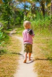 Caminhada descalça feliz da criança apenas na praia pelo trajeto da selva fotos de stock Caminhada descalça feliz da criança apenas na praia pelo trajeto da selva fotos de stock