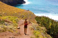 Caminhante fêmea novo da vista traseira que anda para baixo ao mar em Macizo de Anaga em Tenerife imagens de stock Caminhante fêmea novo da vista traseira que anda para baixo ao mar em Macizo de Anaga em Tenerife imagens de stock