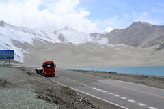 Camion sur la route au lac Bulunkou, dunes de sable et eau bleue de turquoise à sur la route de Karakoram, le Xinjiang photo stock Camion sur la route au lac Bulunkou, dunes de sable et eau bleue de turquoise à sur la route de Karakoram, le Xinjiang photo stock