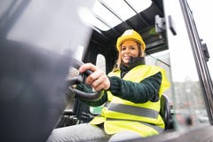 Camionista da empilhadeira da mulher em uma área industrial fotos de stock Camionista da empilhadeira da mulher em uma área industrial fotos de stock