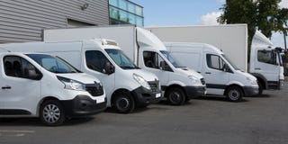 Camions de livraison blancs garés dans le bâtiment d'entrepôt image libre de droits Camions de livraison blancs garés dans le bâtiment d'entrepôt image libre de droits