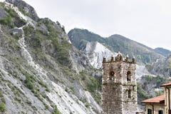 Campanile della chiesa costruita con i ciottoli di marmo bianchi Colonnata, Carrara, Toscana, Italia fotografia stock Campanile della chiesa costruita con i ciottoli di marmo bianchi Colonnata, Carrara, Toscana, Italia fotografia stock