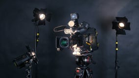 Caméra vidéo numérique professionnelle, camcoder d'isolement sur le fond noir dans le srudio de TV Caméra vidéo numérique professionnelle, camcoder d'isolement sur le fond noir dans le srudio de TV