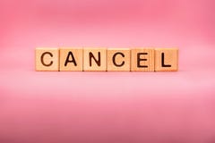 CANCEL word made with building blocks, business concept. Word CANCEL on pink background.