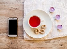 Candele, tazza, bagel e telefono aromatici porpora su una tavola di legno fotografia stock libera da diritti Candele, tazza, bagel e telefono aromatici porpora su una tavola di legno fotografia stock libera da diritti