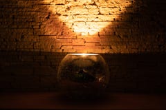 Candle light in dark room inside glass candlestick on beige background stock photo Candle light in dark room inside glass candlestick on beige background stock photo