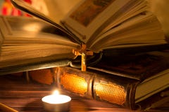 Candles, books and bible on a dark background. The light from the burning candle. Prayer stock image Candles, books and bible on a dark background. The light from the burning candle. Prayer stock image