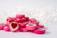 Candys пинка и белых с красными сердцами на белой предпосылке стоковые изображения Candys пинка и белых с красными сердцами на белой предпосылке стоковые изображения