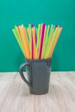Caneca cerâmica enchida com as palhas plásticas de diversas cores imagens de stock Caneca cerâmica enchida com as palhas plásticas de diversas cores imagens de stock