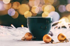 Caneca de café com bokeh das luzes e bolas douradas com conceito borrado do Natal do fundo fotografia de stock royalty free Caneca de café com bokeh das luzes e bolas douradas com conceito borrado do Natal do fundo fotografia de stock royalty free