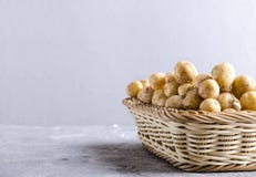 Canestro di vimini in pieno di nuove patate della molla Patate novelle crude nel contenitore fatto delle fibre rigide sulla super fotografie stock libere da diritti Canestro di vimini in pieno di nuove patate della molla Patate novelle crude nel contenitore fatto delle fibre rigide sulla super fotografie stock libere da diritti