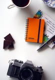 Canon Gray and Black Bridge Camera Near Orange and Blue Spiral Notebook Royalty Free Stock Image Canon Gray and Black Bridge Camera Near Orange and Blue Spiral Notebook Royalty Free Stock Image