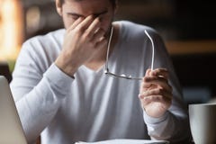 Cansado do homem de negócios do computador decolar vidros sente a fadiga ocular fotos de stock Cansado do homem de negócios do computador decolar vidros sente a fadiga ocular fotos de stock