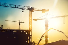 Canteiro de obras resistente industrial com guindastes de torre e silhuetas da construção imagens de stock Canteiro de obras resistente industrial com guindastes de torre e silhuetas da construção imagens de stock