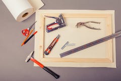 Canvas artist on roll, stretcher for canvas, staple gun and other tools on a gray background royalty free stock images Canvas artist on roll, stretcher for canvas, staple gun and other tools on a gray background royalty free stock images