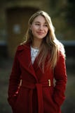 Capa roja que lleva que camina de la mujer joven foto de archivo libre de regalías Capa roja que lleva que camina de la mujer joven foto de archivo libre de regalías