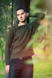 Capelli di scarsità di modello dell'uomo che pendono contro un albero in una scena della natura fotografia stock Capelli di scarsità di modello dell'uomo che pendono contro un albero in una scena della natura fotografia stock