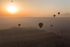 Горячие воздушные шары поднимая над горизонтом Cappadocia в рано утром стоковые изображения Горячие воздушные шары поднимая над горизонтом Cappadocia в рано утром стоковые изображения