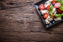 Caprese Salad.Mediterranean salad. Mozzarella cherry tomatoes basil and olive oil on old oak table. Italian cuisine Stock Images Caprese Salad.Mediterranean salad. Mozzarella cherry tomatoes basil and olive oil on old oak table. Italian cuisine Stock Images