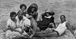 Capri, Itália, 1932 - um grupo de meninos e as meninas com um cão relaxam no sol de Capri foto de stock Capri, Itália, 1932 - um grupo de meninos e as meninas com um cão relaxam no sol de Capri foto de stock