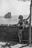 Capri, Ιταλία, 1932 - μια όμορφη τοποθέτηση κοριτσιών σκεπτικά σε ένα κοστούμι λουσίματος στοκ εικόνες Capri, Ιταλία, 1932 - μια όμορφη τοποθέτηση κοριτσιών σκεπτικά σε ένα κοστούμι λουσίματος στοκ εικόνες
