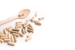 Capsule di erbe mediche con il cucchiaio isolato fotografia stock Capsule di erbe mediche con il cucchiaio isolato fotografia stock