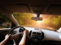 Car Dashboard With Driver`s Hands On The Steering Wheel And Rear View Mirrors On A Road In Motion With Trees Against Sky With Stock Image Car Dashboard With Driver`s Hands On The Steering Wheel And Rear View Mirrors On A Road In Motion With Trees Against Sky With Stock Image