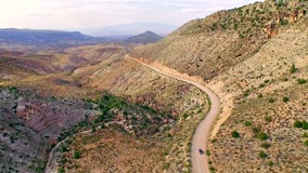 Car driving on a dirt road through dry Arizona desert