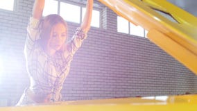 Car repair service. Young woman opening the car hood and looking inside stock footage Car repair service. Young woman opening the car hood and looking inside stock footage