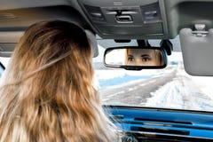 In the car on the winter road you can see the eyes in the rear-view mirror of the blonde girl sitting behind the wheel royalty free stock photos In the car on the winter road you can see the eyes in the rear-view mirror of the blonde girl sitting behind the wheel royalty free stock photos