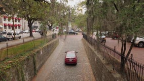 Car Travels Up Narrow Cobblestone Savannah Street stock video footage Car Travels Up Narrow Cobblestone Savannah Street stock video footage