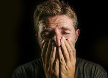 Cara desesperada gritadora triste y devastada joven de la cubierta del hombre con sus manos que sienten dolor y depresión sufrido imagenes de archivo Cara desesperada gritadora triste y devastada joven de la cubierta del hombre con sus manos que sienten dolor y depresión sufrido imagenes de archivo