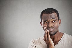 Cara tocante do homem novo que tem a dor realmente má do dente da dor imagem de stock royalty free Cara tocante do homem novo que tem a dor realmente má do dente da dor imagem de stock royalty free