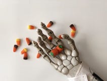 Caramella di scheletro della tenuta in sua mano immagini stock libere da diritti Caramella di scheletro della tenuta in sua mano immagini stock libere da diritti