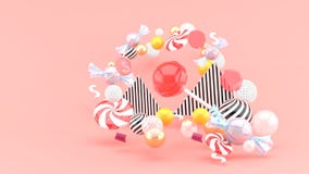 Caramelo entre bolas coloridas en fondo rosado imagenes de archivo Caramelo entre bolas coloridas en fondo rosado imagenes de archivo