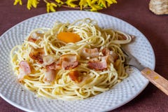 Carbonara della pasta Fiori nei precedenti Alimento italiano fotografia stock Carbonara della pasta Fiori nei precedenti Alimento italiano fotografia stock