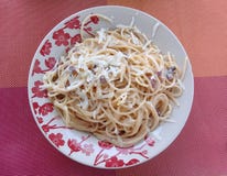 Carbonara μακαρονιών σε ένα πιάτο με το σχέδιο λουλουδιών στοκ φωτογραφία με δικαίωμα ελεύθερης χρήσης Carbonara μακαρονιών σε ένα πιάτο με το σχέδιο λουλουδιών στοκ φωτογραφία με δικαίωμα ελεύθερης χρήσης