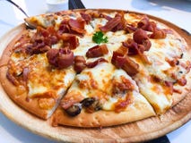 Carbonarapizza met Gerookte bacon, Ham, Paddestoel, van Cherry Tomato, van het Ei, van de Kaas en van de Room Saus die op de hout stock afbeelding Carbonarapizza met Gerookte bacon, Ham, Paddestoel, van Cherry Tomato, van het Ei, van de Kaas en van de Room Saus die op de hout stock afbeelding