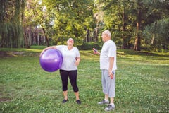 Cardio- exercice pour la femme supérieure heureuse supérieure avec des boules de forme physique en parc photos libres de droits Cardio- exercice pour la femme supérieure heureuse supérieure avec des boules de forme physique en parc photos libres de droits